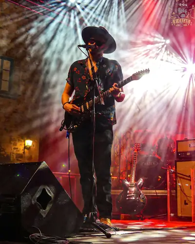 Guitarrista con sombrero entre los focos