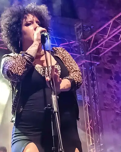 Cantante al micrófono bajo luz morada