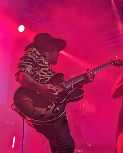 Guitarrista con sombrero bajo luz roja
