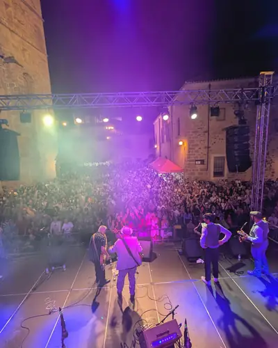 Escenario y público de noche bajo luces de colores