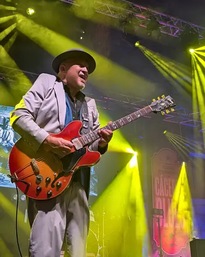 Guitarrista con sombrero bajo luces amarillas